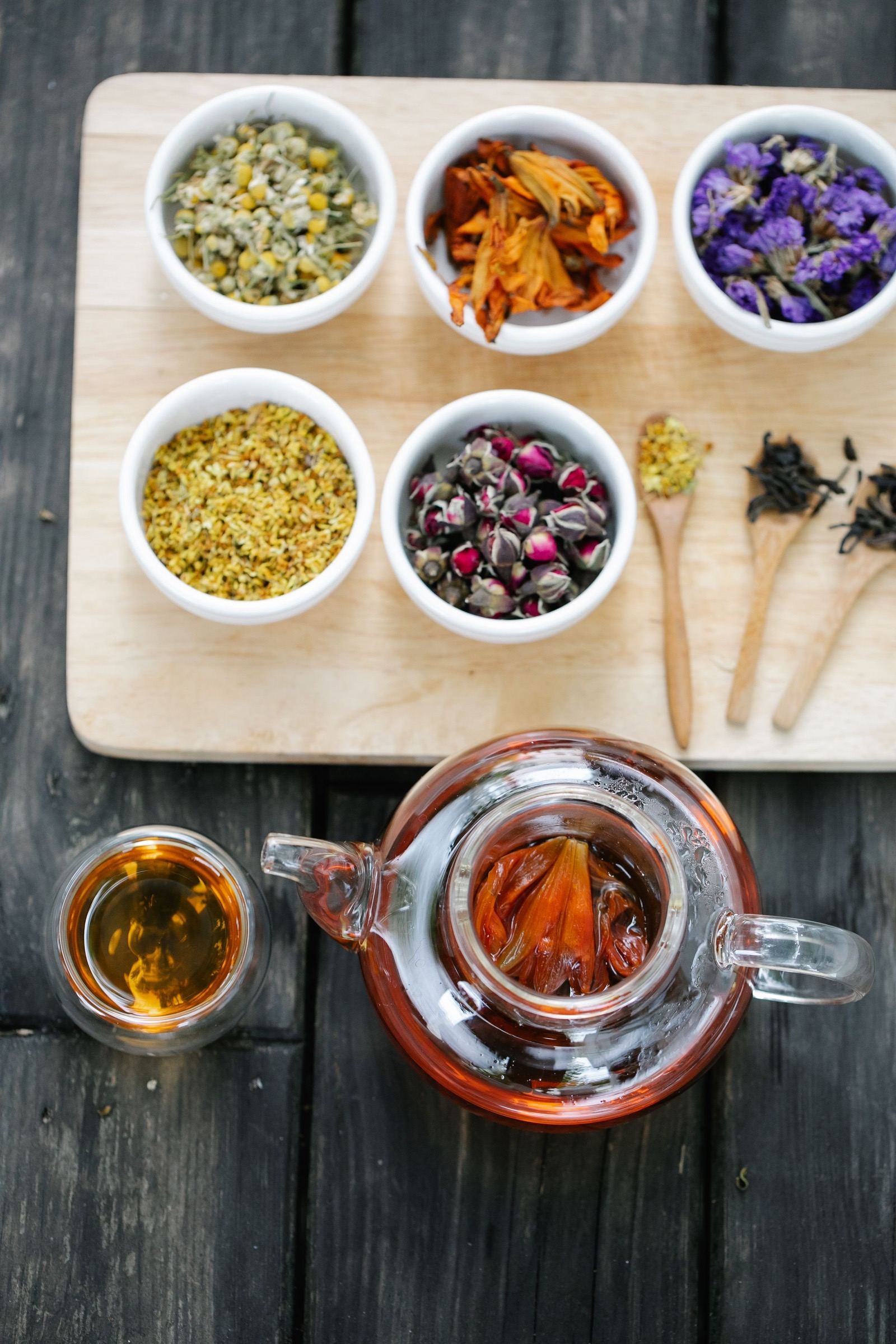 Bowls of dried flowers, buds, and loose herbs used for herbal tea